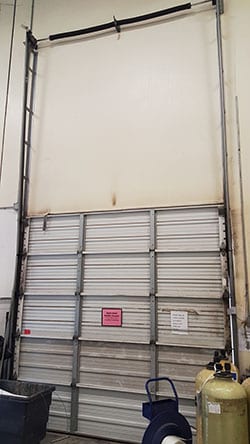 Commercial overhead garage door broken panel is repaired in Richardson Texas by Action Garage Doors highly qualified technician