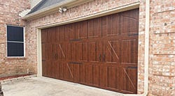 A custom wood residential garage door installed and repaired by technician 2 in Garland Texas by Action Garage Doors of Plano Tx