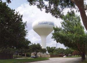 Picture of one of Sugar Land Texas' water towers with a fire station in the background.