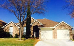 This residential brick veneer home with two single car steel garage doors for repairs and installation in Trophy Club Texas by Action Garage Doors